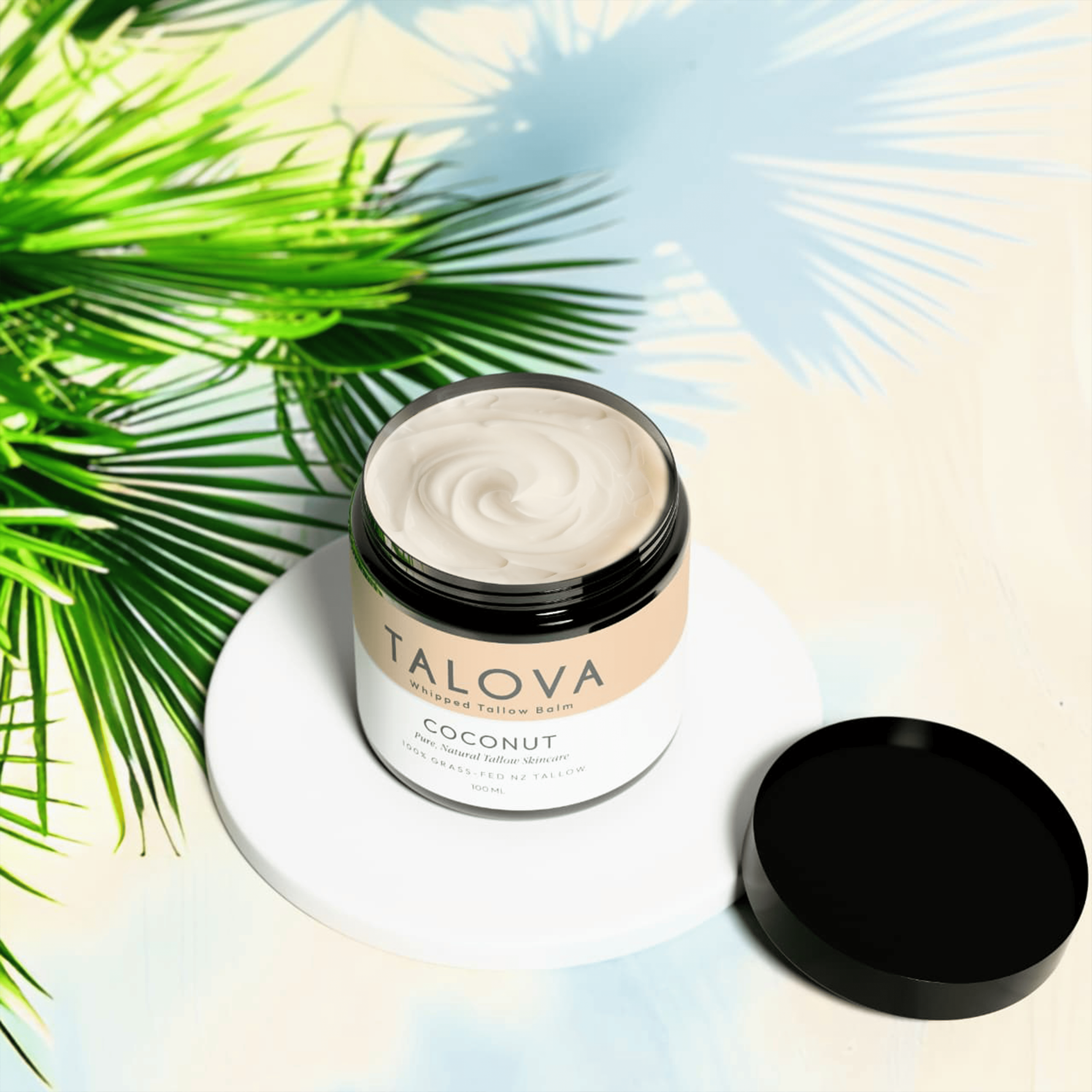 Talova coconut whipped tallow balm 100ml open jar on white plate with flowers moody background