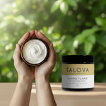 Talova ylang ylang whipped tallow balm 100ml in hands cupping open jar with greenery background